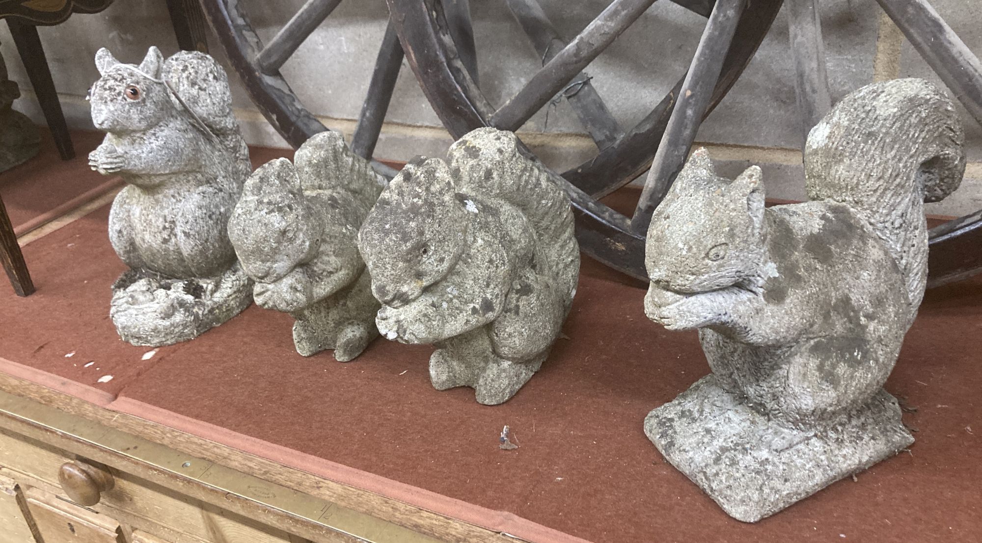 Four reconstituted stone squirrel garden ornaments, largest 26cm high
